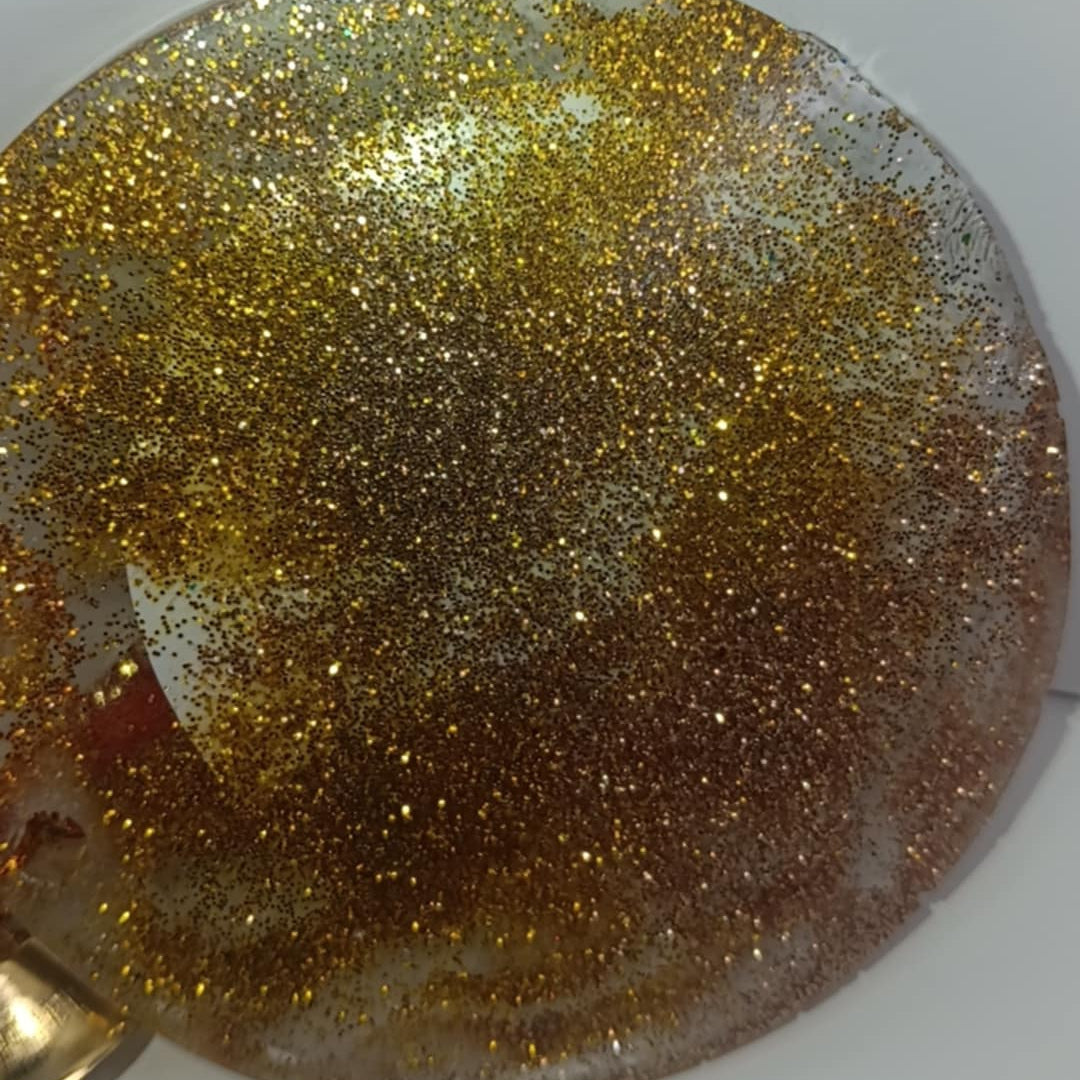 Round gold glittery object on a white background