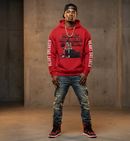 Person wearing a red hoodie with 'Heart Breaker Club' text and graphics, standing against a concrete wall.