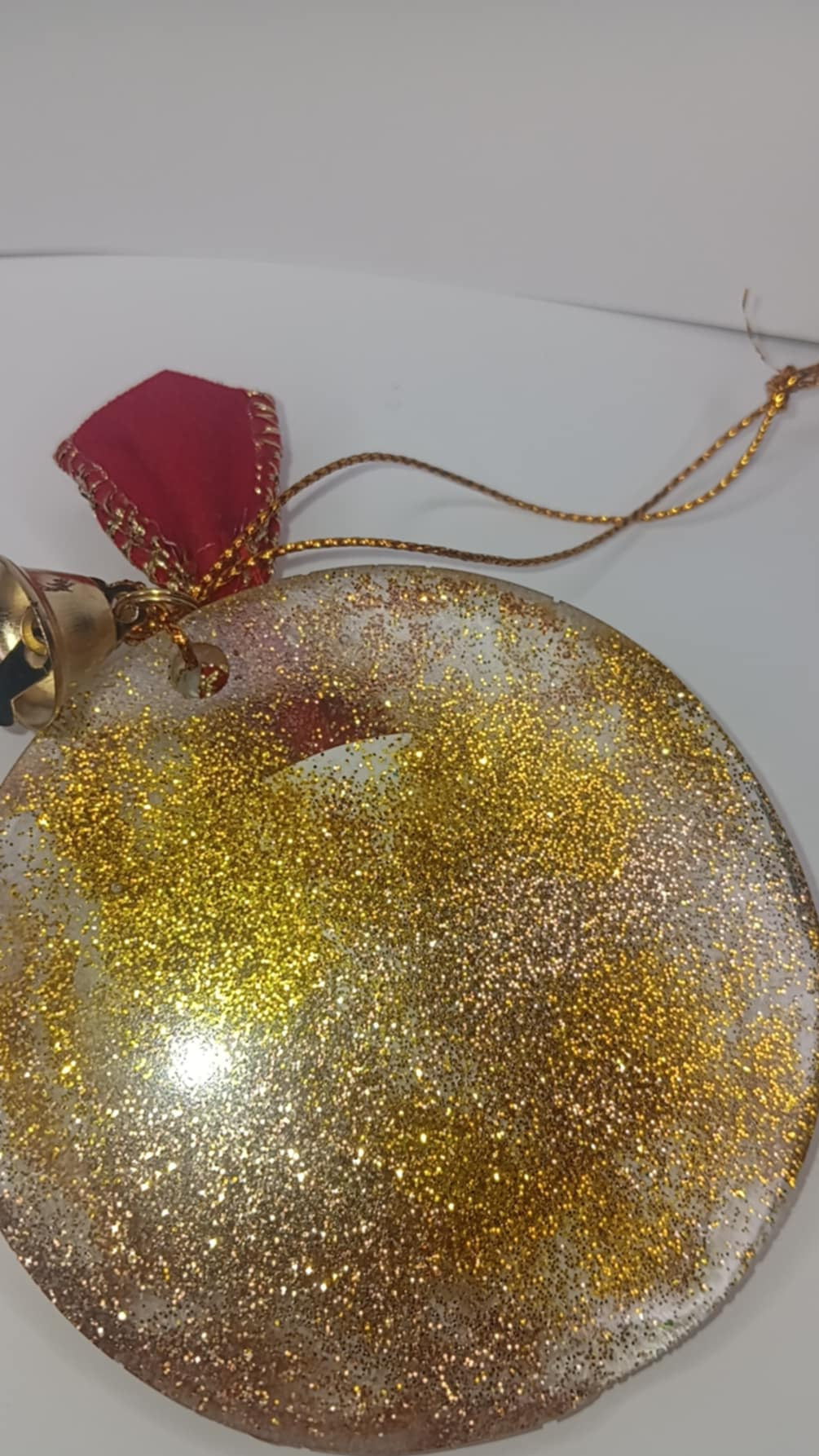 Decorative ornament with gold glitter and red top on a white background
